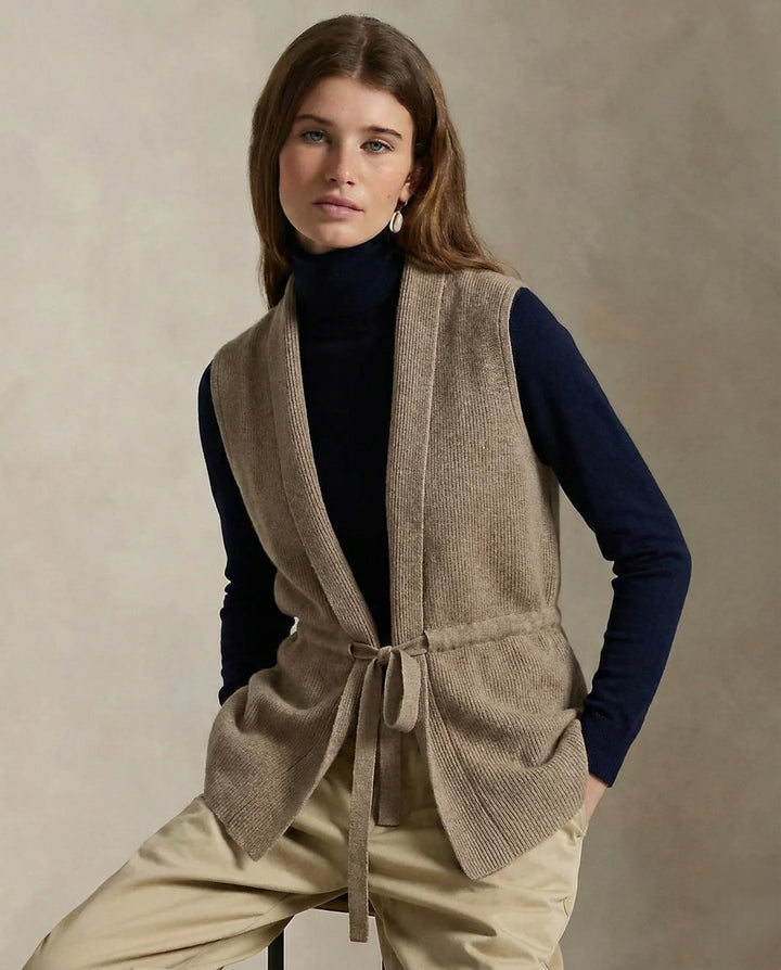 Woman wearing the beige vest with the waist tie fastened for a tailored look