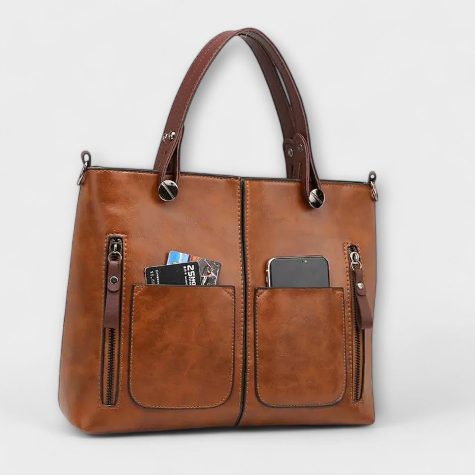 Close-up view of tote bag front pockets with zip compartments and stitched edges