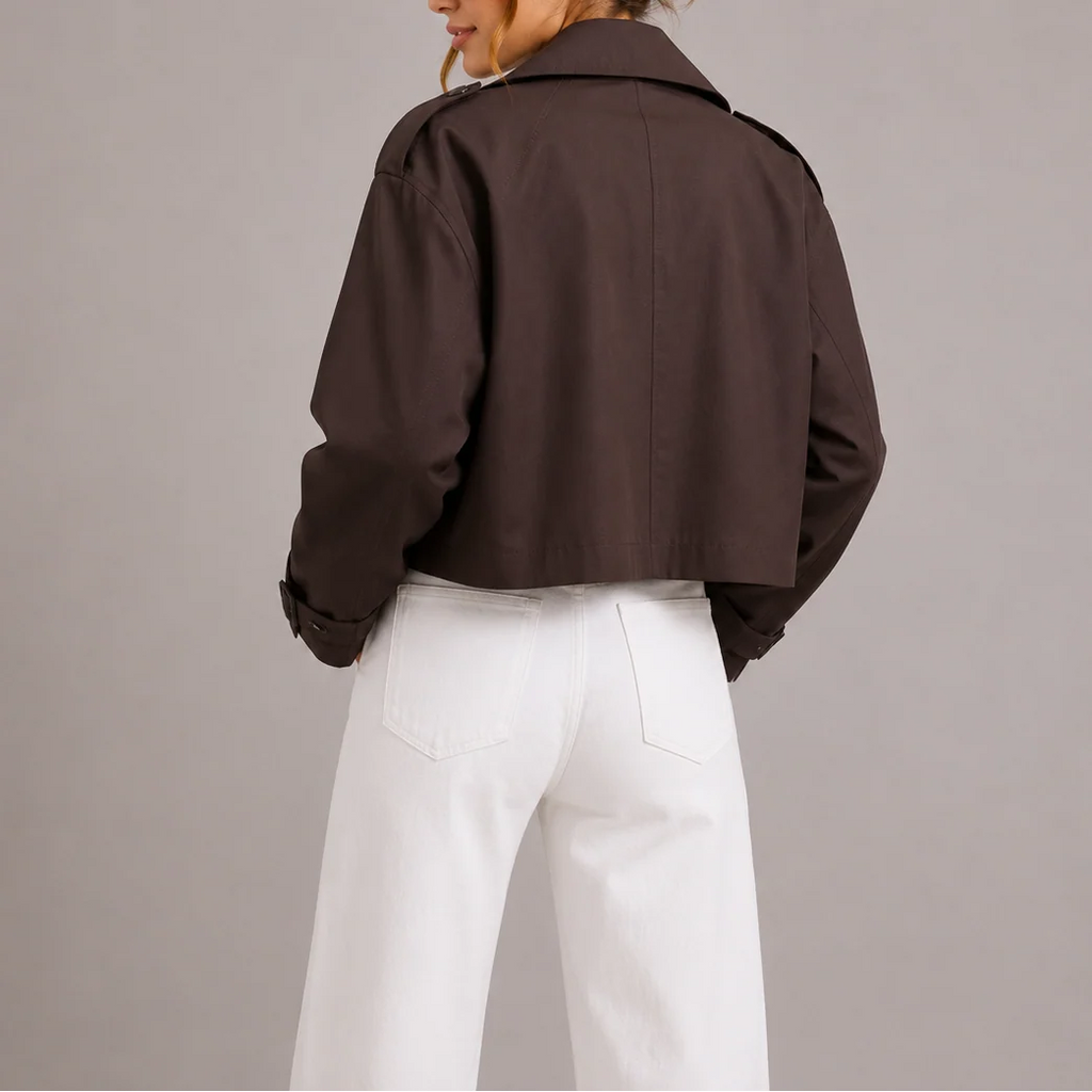 Close-up view of cropped trench jacket showing structured fabric and shoulder epaulette detail