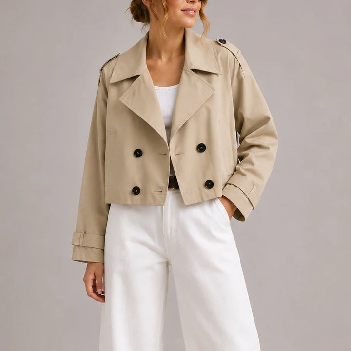 Side view of brown cropped trench jacket with belted cuff tabs and relaxed fit
