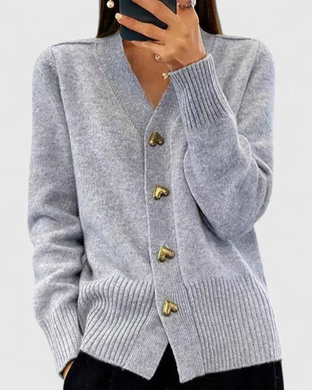 Close-up of heart-shaped button fastenings on women's navy knit cardigan