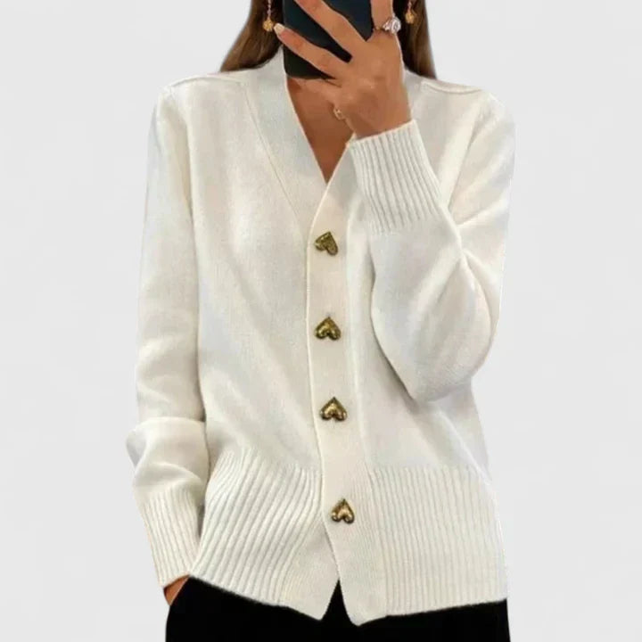 Detail of ribbed collar and heart button closure on women's cardigan