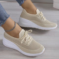 Women's knit trainers in beige with lace-up closure and chunky white sole on feet