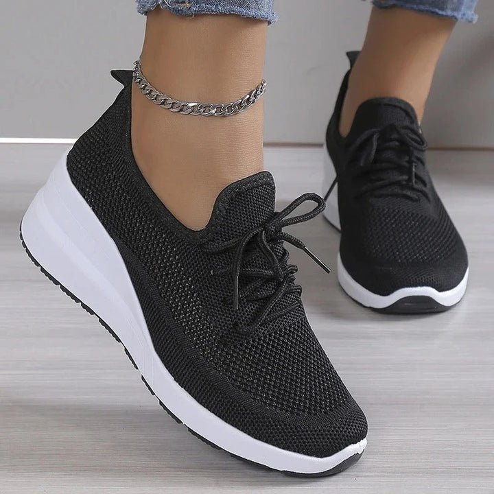 Women's knit trainers in beige worn with jeans showing comfortable everyday fit