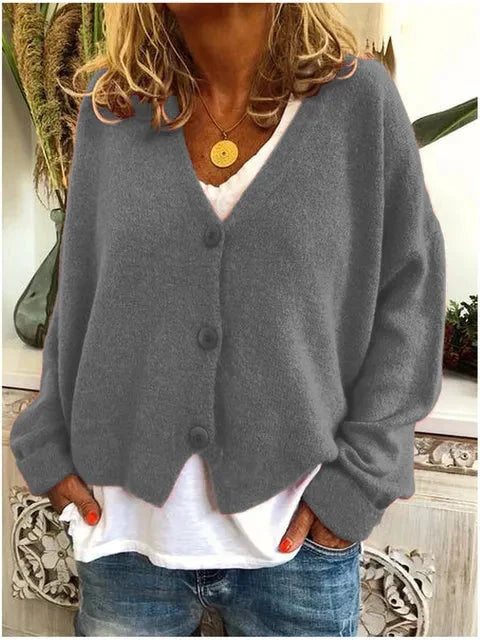 Detail of V-neckline and ribbed cuffs on relaxed knit cardigan
