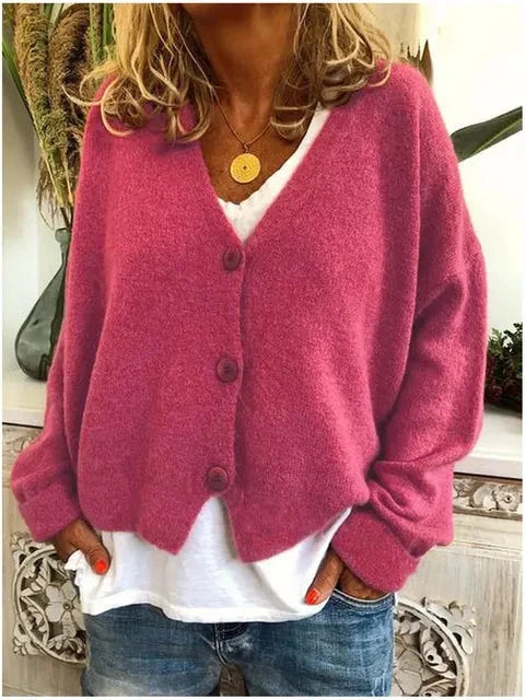 Relaxed knit cardigan worn casually with denim and layered accessories