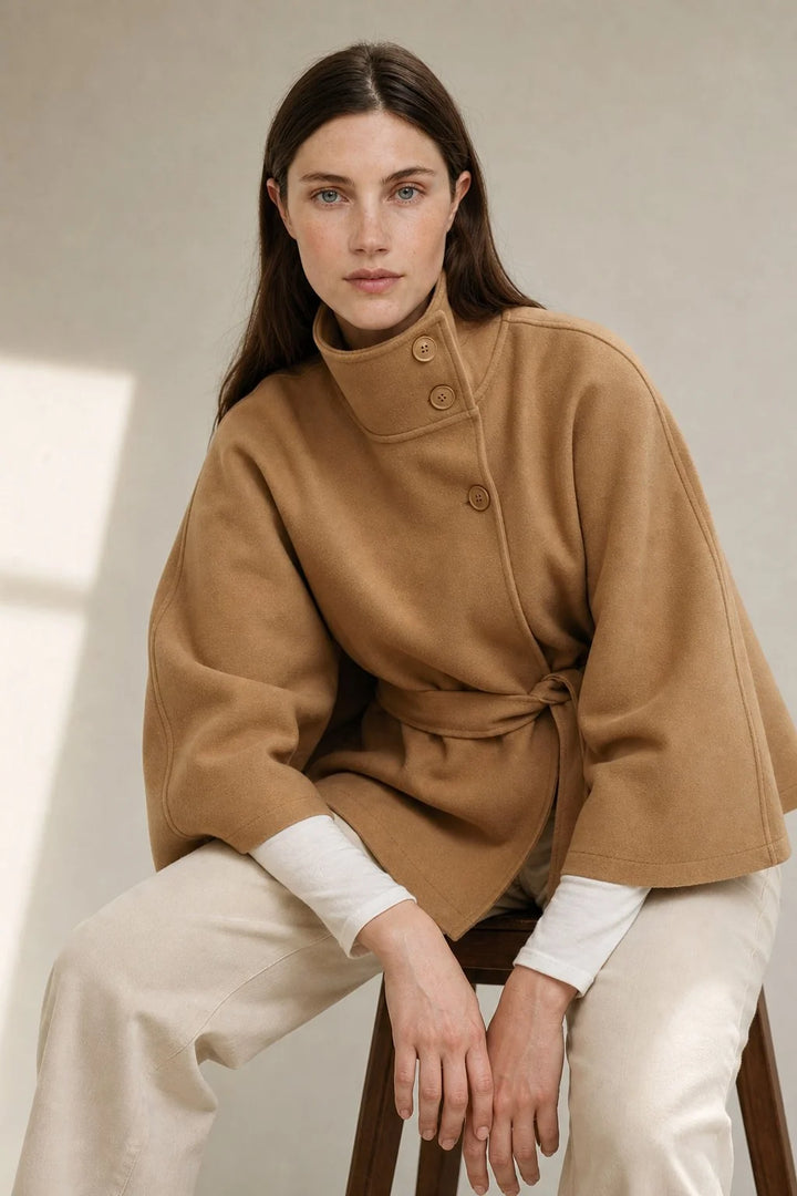 Model demonstrating cape sleeve openings on wool coat