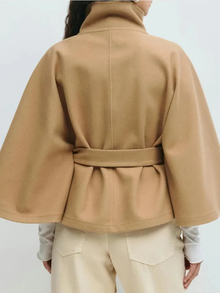 Women's cape coat showing adjustable belt tied at waist