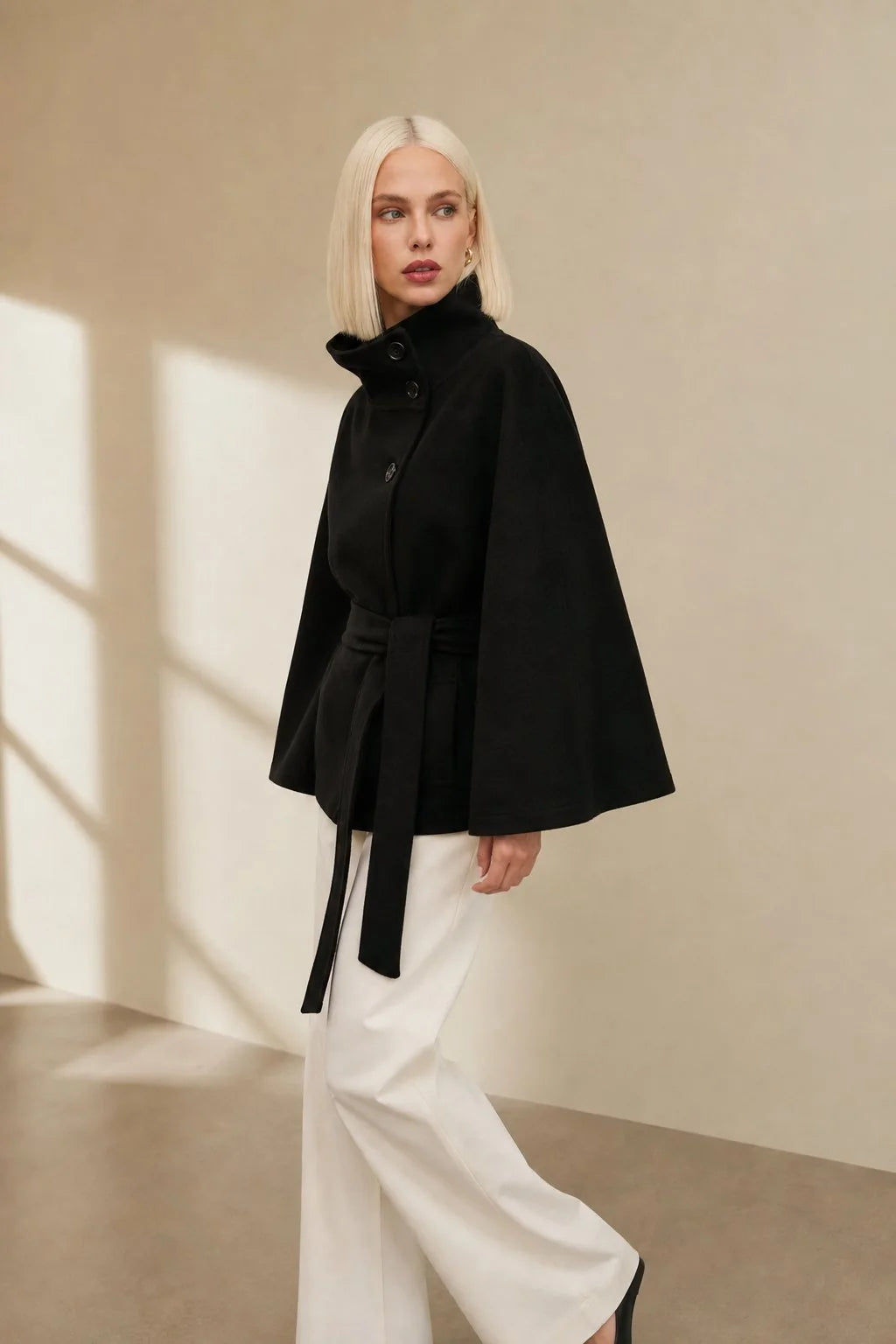Detail of adjustable waist belt on women's wool cape coat