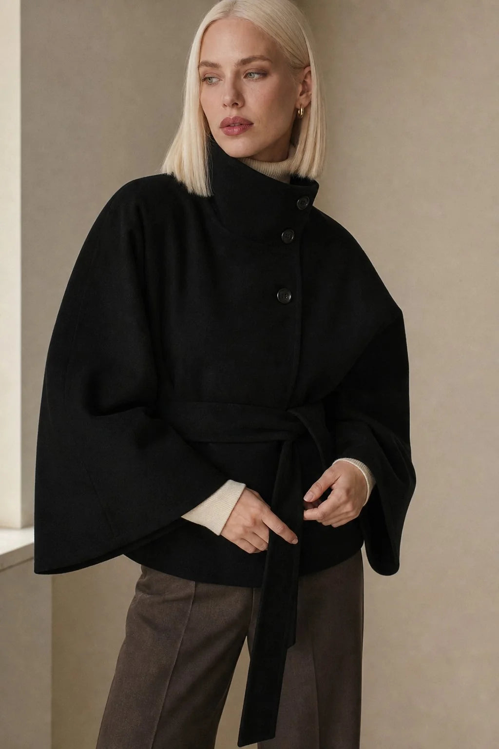 Back view of cape coat showing draped fabric and relaxed fit