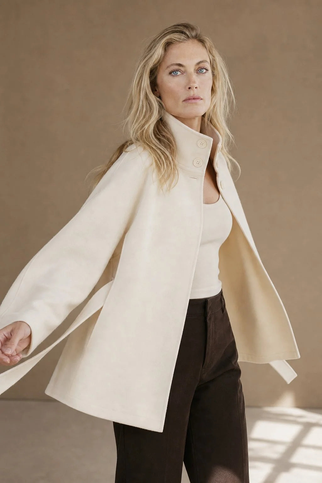 Women's wool cape coat styled over knitwear for autumn layering