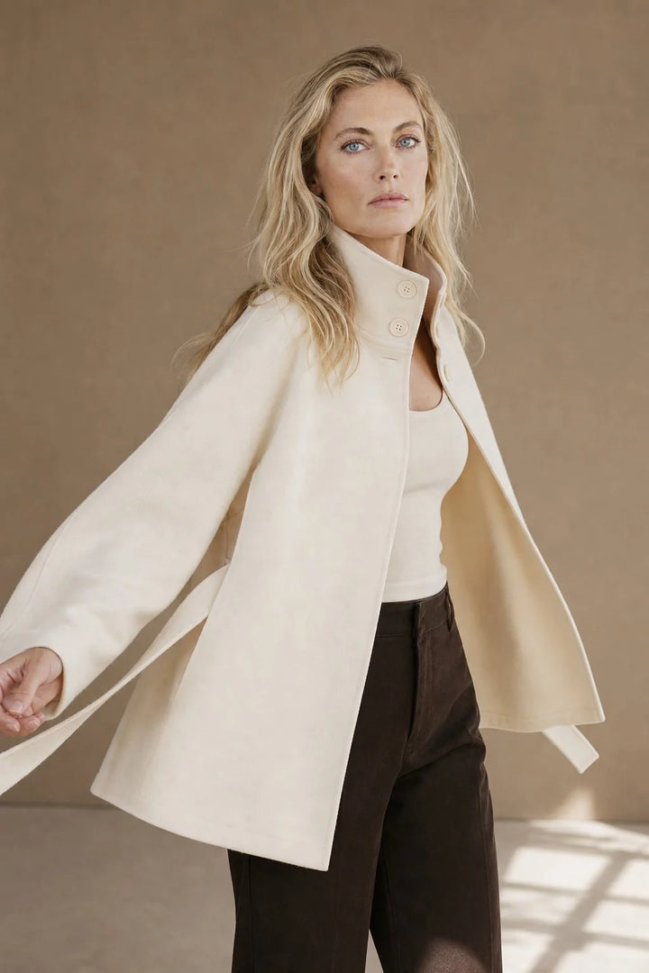 Women's wool cape coat styled over knitwear for autumn layering