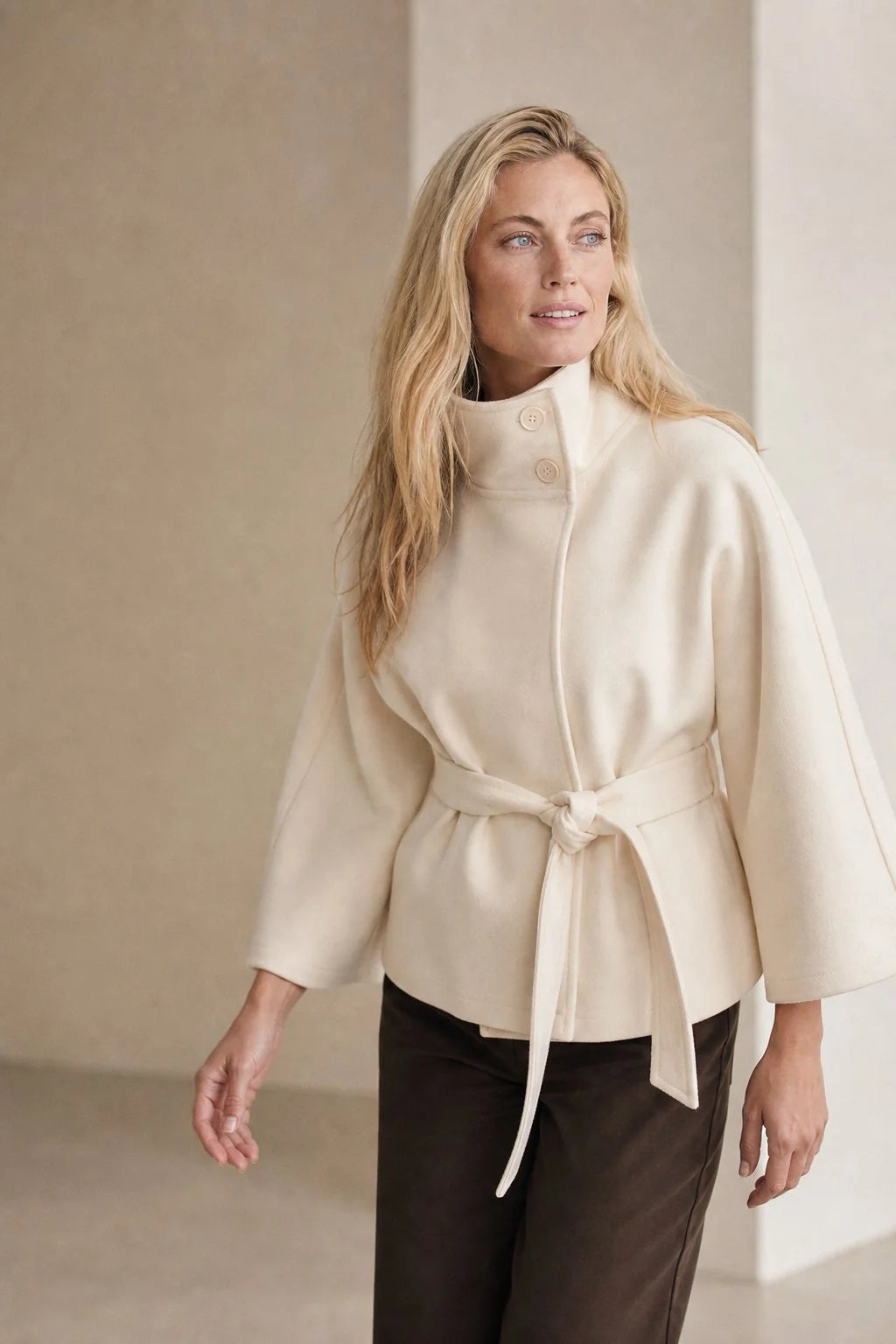 Front button closure detail on stand collar wool cape coat