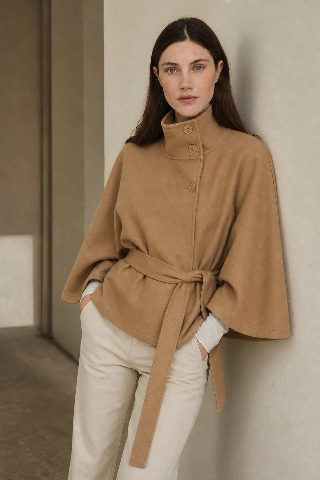 Full-length view of women's cape coat in black showing hip-length cut