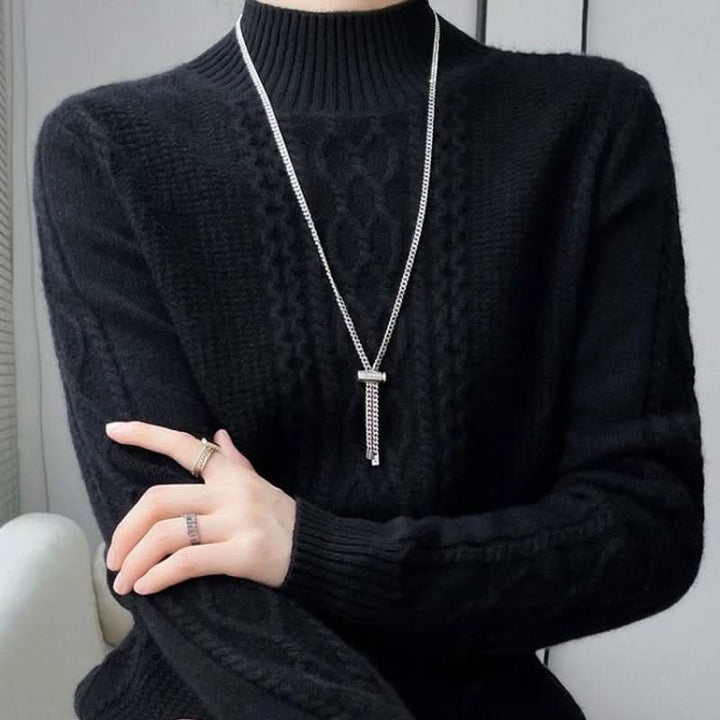 Full view of pink cable knit jumper with high neckline and relaxed silhouette