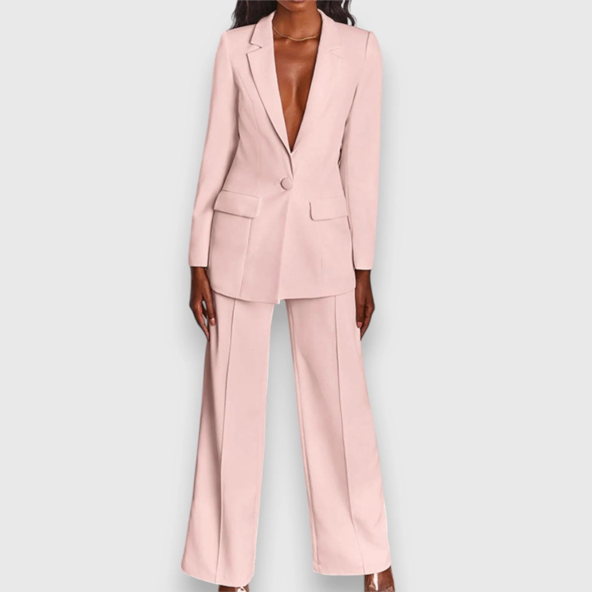 Women's tailored suit set in pale pink featuring single-breasted blazer and wide-leg trousers on model