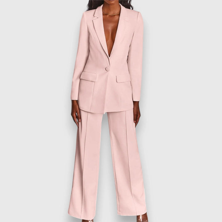 Women's tailored suit set in pale pink featuring single-breasted blazer and wide-leg trousers on model