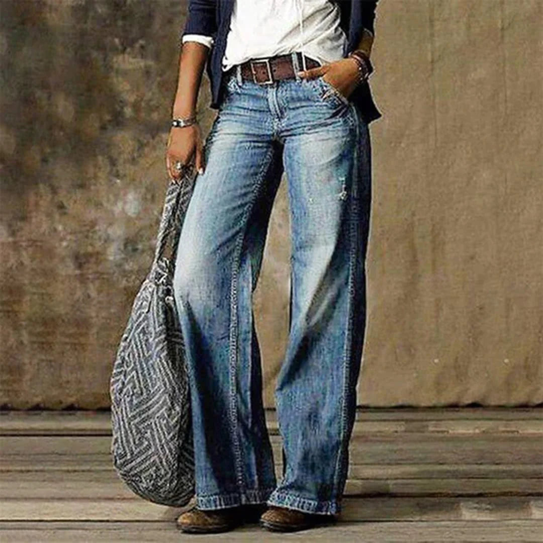 Women's wide leg jeans with vintage fading and relaxed fit, styled with white tee and brown belt