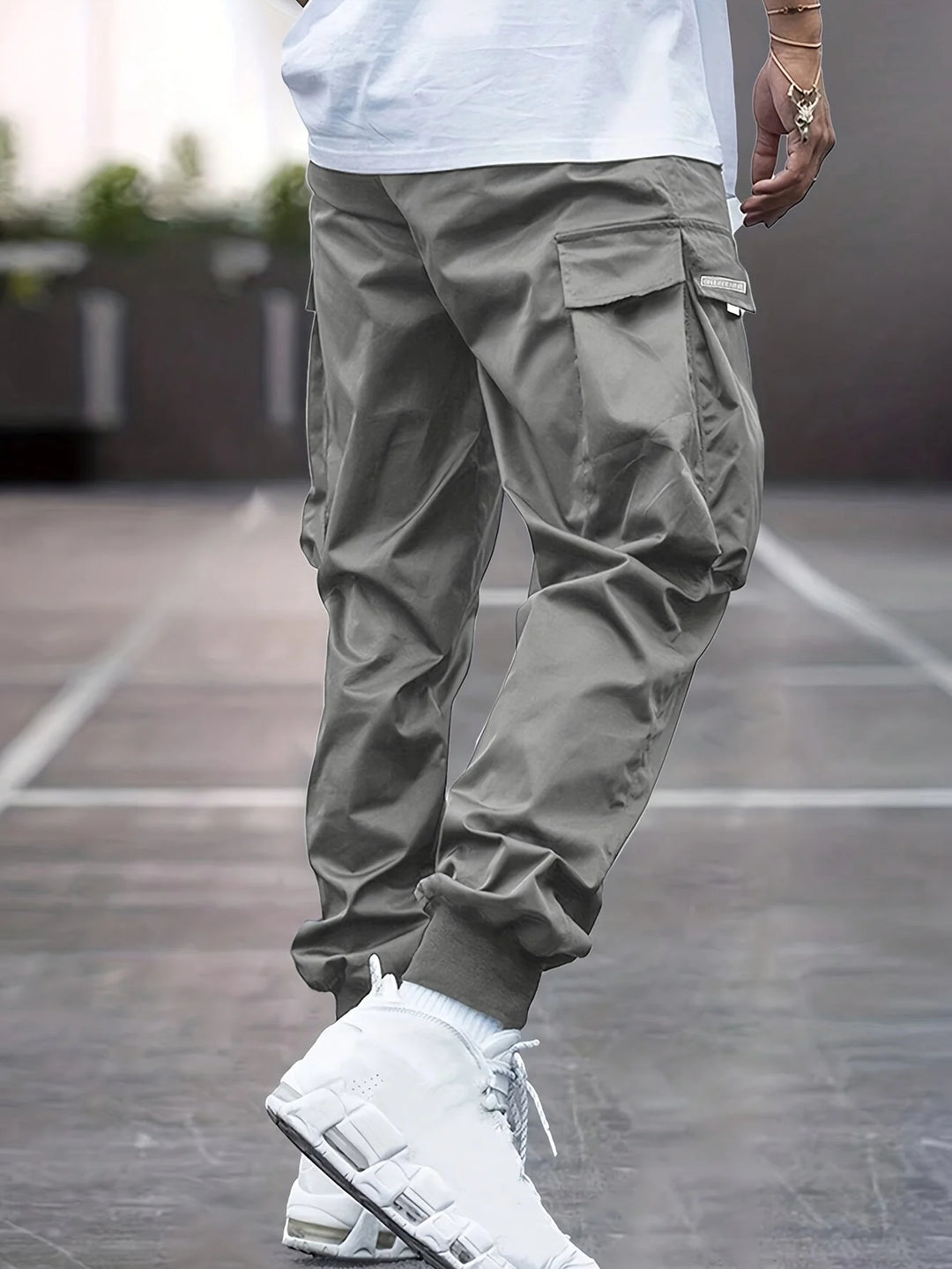 Close-up of cargo trouser pocket with flap closure and drawstring waist detail