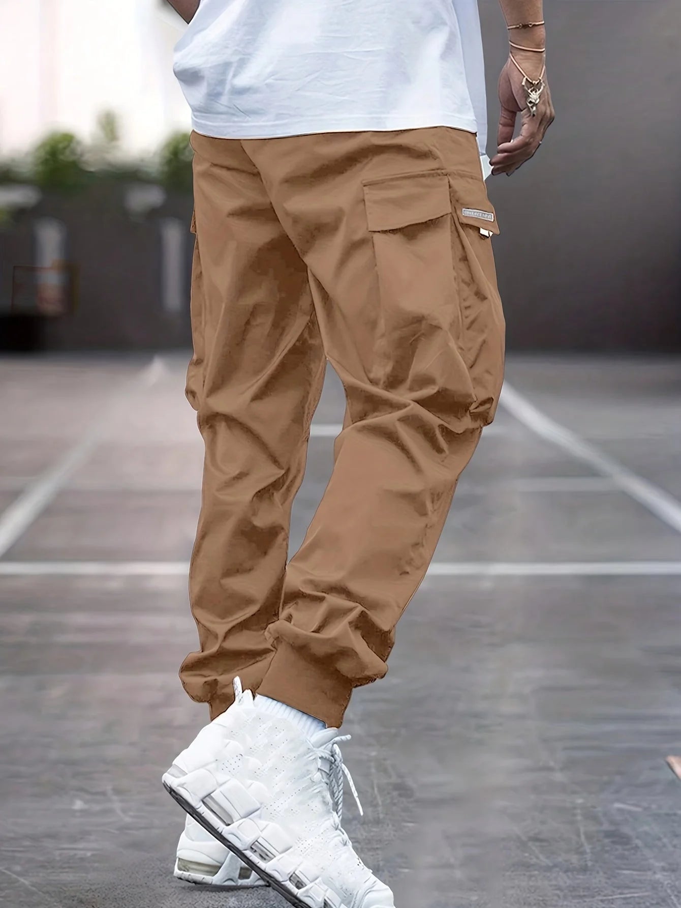 Full-length view of men's cargo trousers showing tapered silhouette and ankle cuff construction