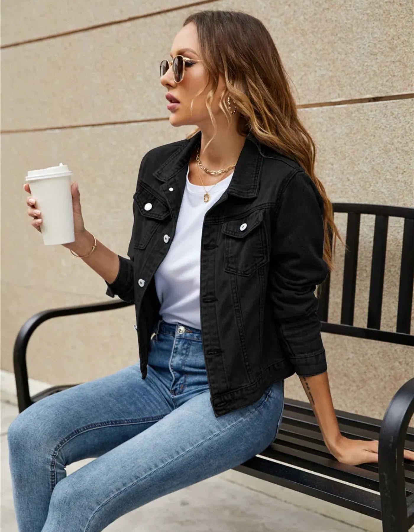 Close-up of cropped denim jacket showing structured collar and button-front closure detail