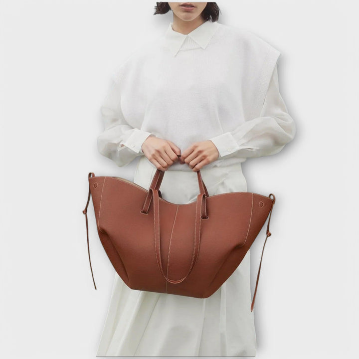 Curved shoulder bag side profile showing detachable strap and structured silhouette