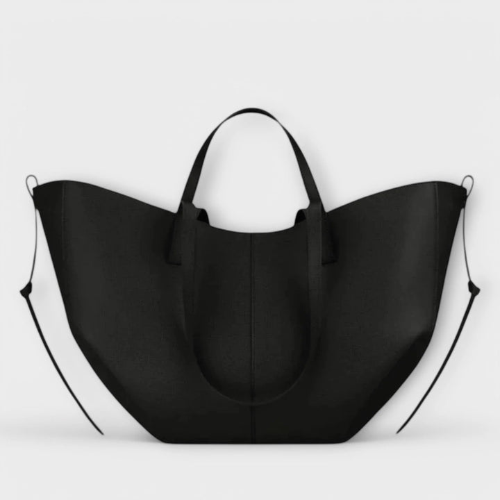 Women's structured tote bag side view displaying crescent silhouette and adjustable shoulder strap