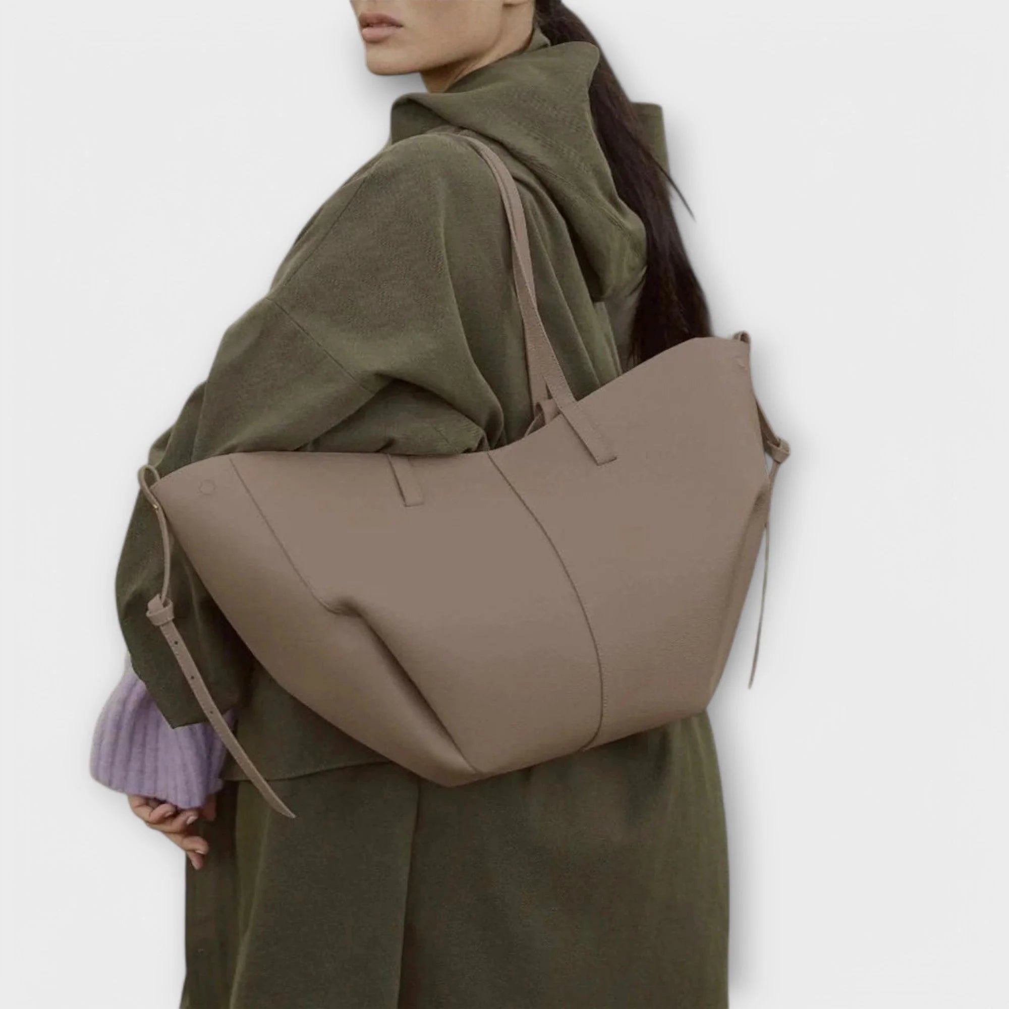 Women's minimalist tote bag flat lay showing dual handles and side tab details