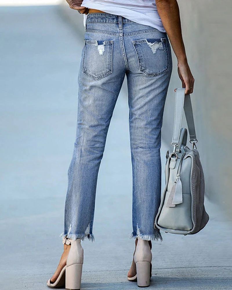 Mid-rise distressed jeans showing straight leg silhouette and cropped length detail