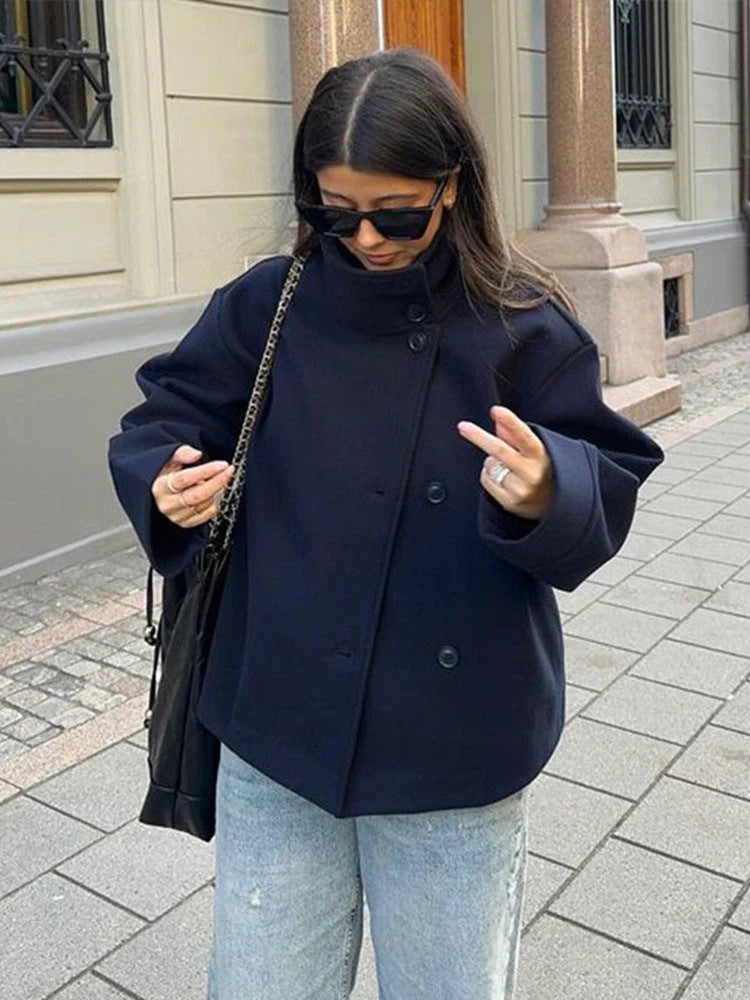 Close-up of women's oversized wool coat showing structured lapel collar and button detail