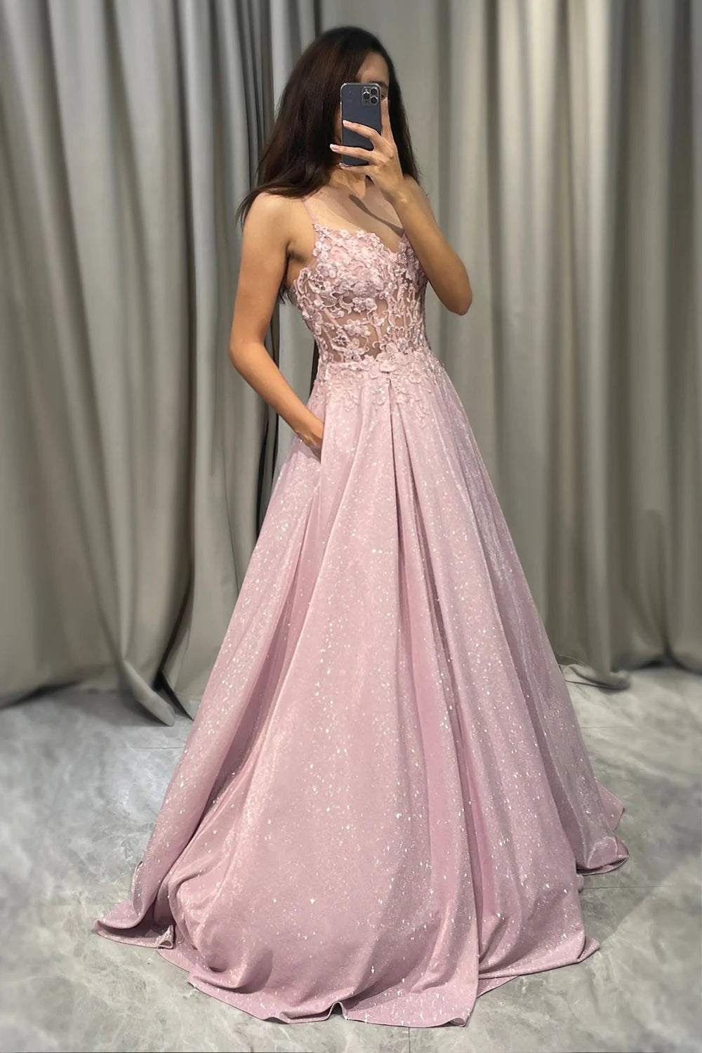 Back view of embellished maxi dress showing spaghetti strap detail and full skirt drape