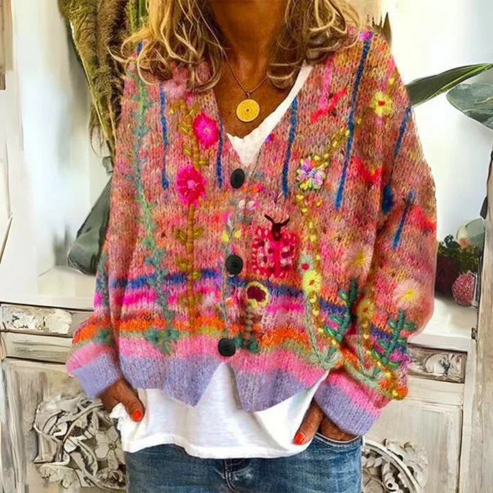 Relaxed fit women's cardigan with artistic floral motifs and V-neckline, paired with denim jeans