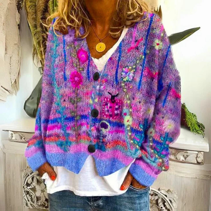 Detailed shot of colourful embroidered flowers and button closure on women's knit cardigan