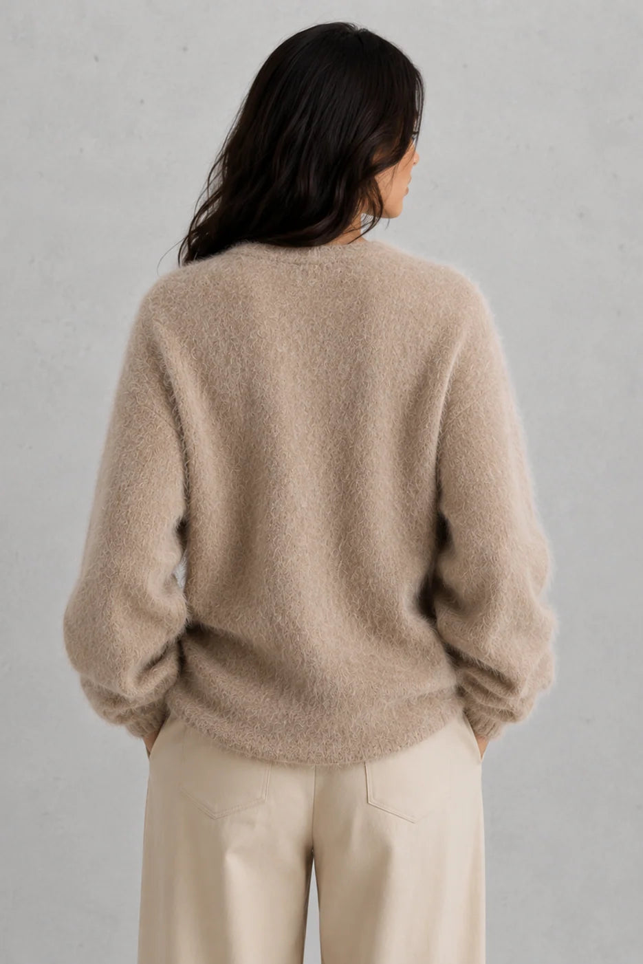 Woman styling button-front cardigan open over fitted top for casual layering look