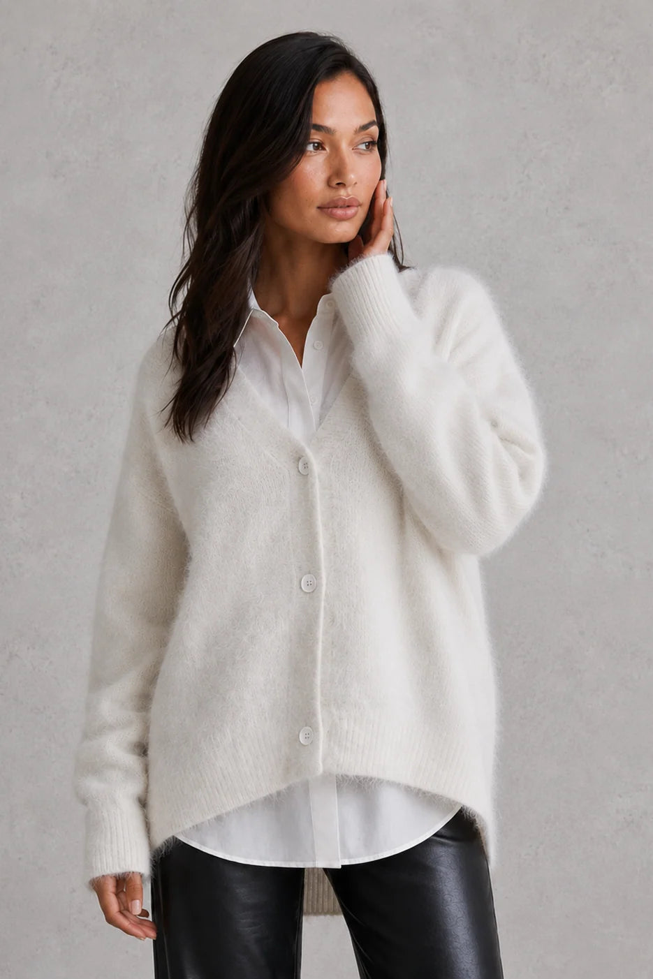 Woman wearing fluffy cardigan buttoned up with gathered sleeve cuffs visible