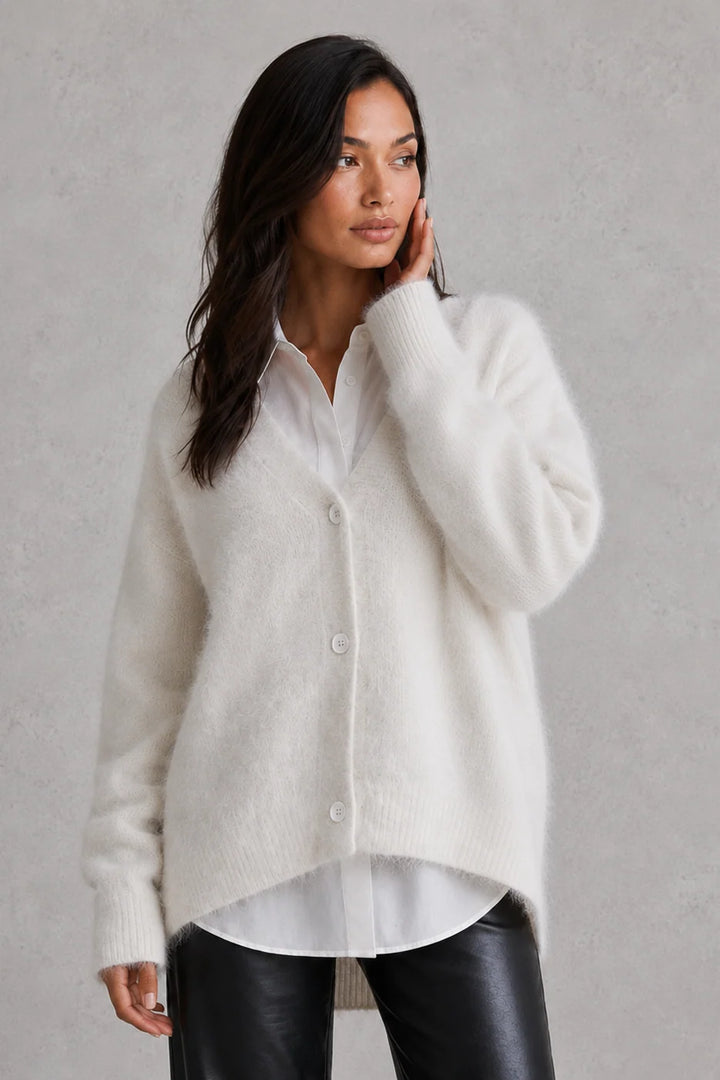Woman wearing fluffy cardigan buttoned up with gathered sleeve cuffs visible