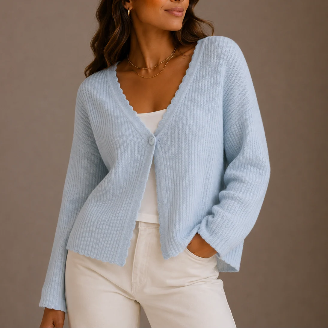 Woman wearing a pale blue women's knit cardigan with V-neckline and button-front detail over white top