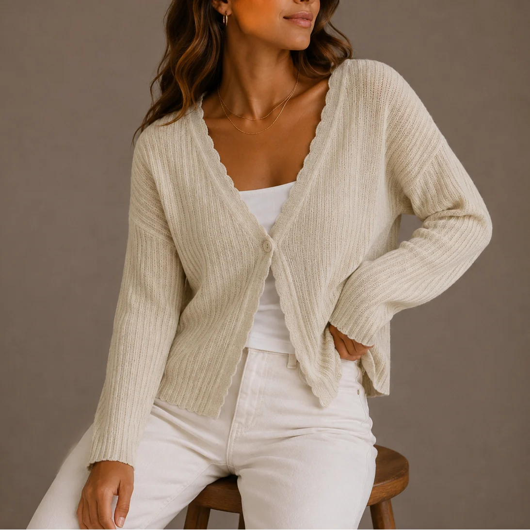 Full outfit view of women's knit cardigan layered over white camisole with neutral bottoms