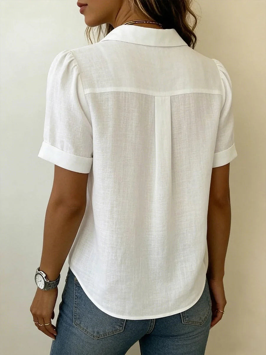 Close-up view of pleated front blouse showing vertical pleats and V-neckline detail with open collar