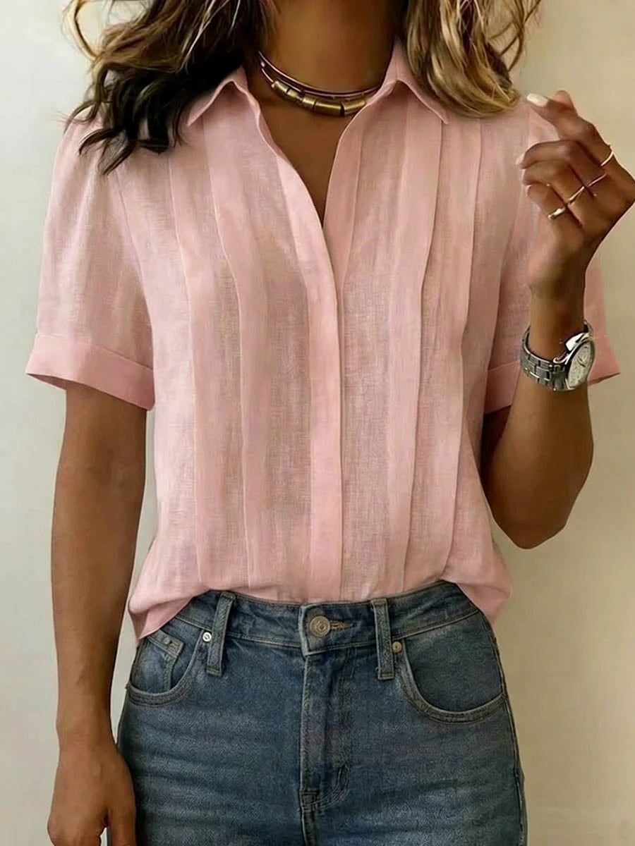 Woman styling pleated front blouse tucked into jeans showing relaxed silhouette and hip-length fit