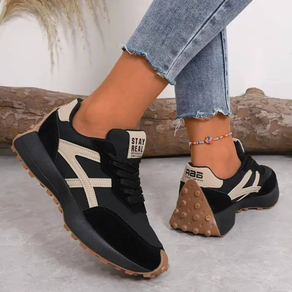 Side view of women's retro trainers showing contrast stripe detailing and padded collar