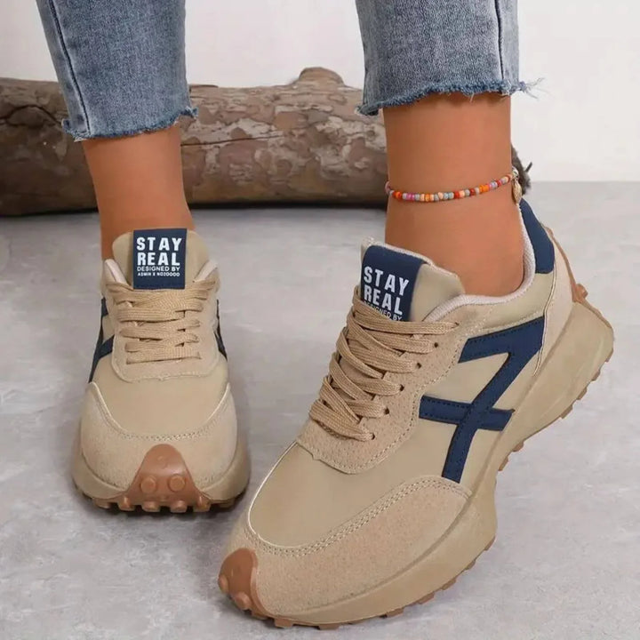 Women's retro trainers styled with cropped jeans and beaded anklet for casual wear