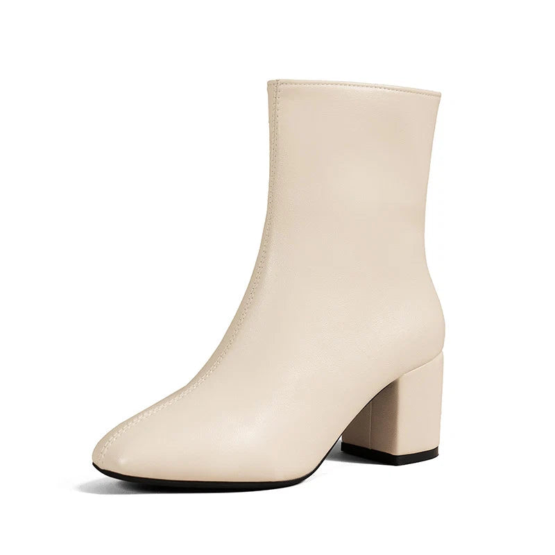 Detail of women's block heel ankle boots in cream with side zip fastening and polished finish