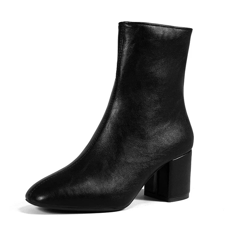 Close-up of structured cream ankle boots featuring stable block heel and clean design lines