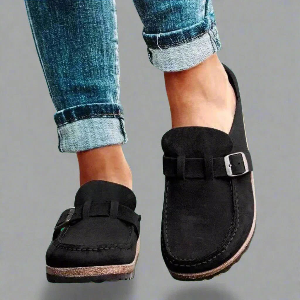 Close-up view of women's buckle mules showing contoured footbed and chunky textured sole construction