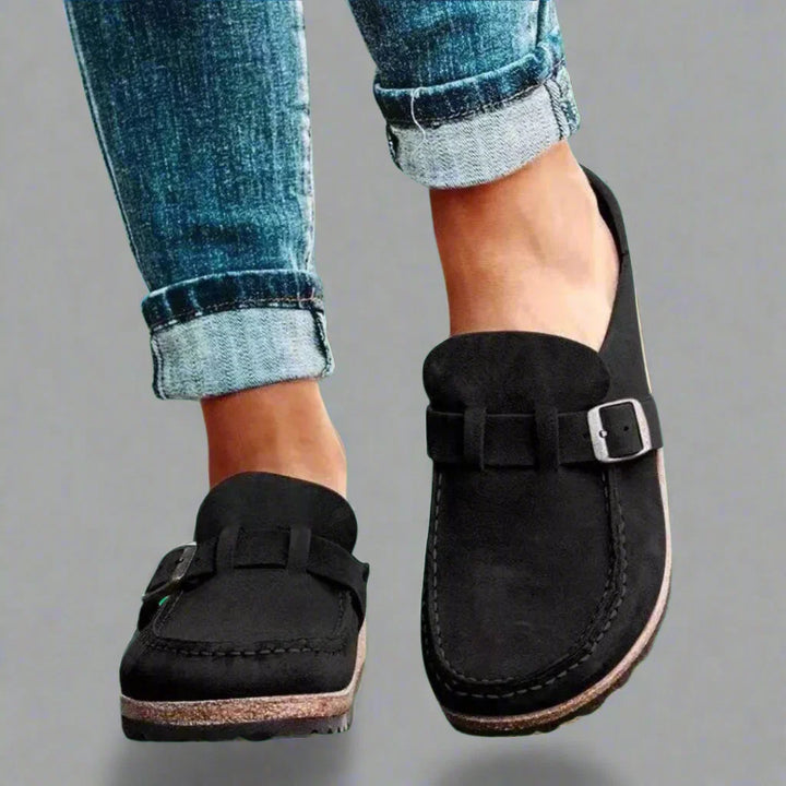 Close-up view of women's buckle mules showing contoured footbed and chunky textured sole construction