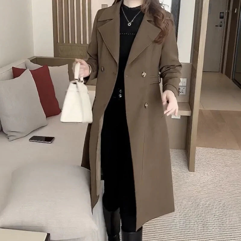Side view of women's mid-length trench coat displaying flowing silhouette and structured fabric drape