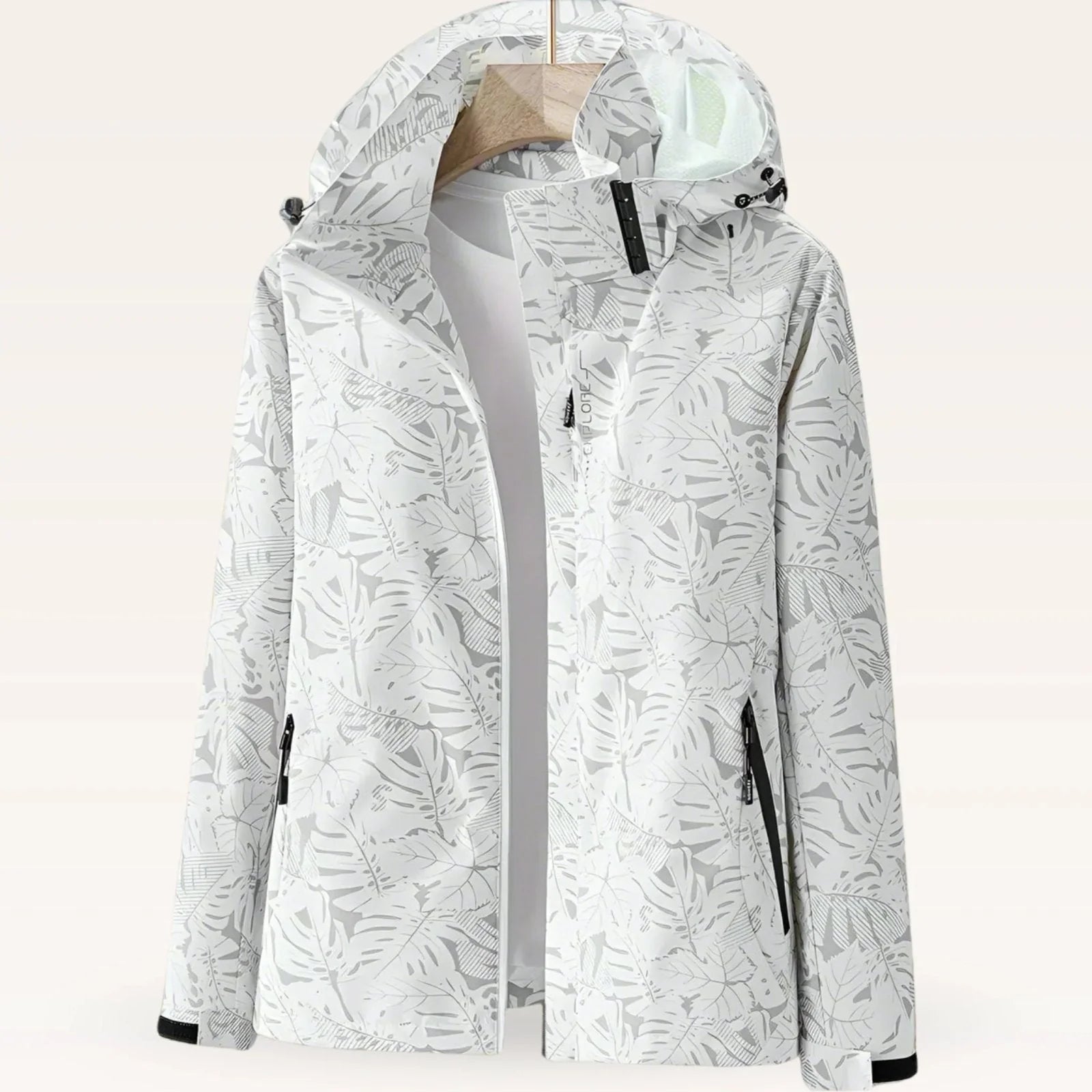 Women's hooded windbreaker jacket with tropical leaf print and adjustable hood on hanger