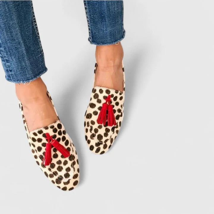 Women's leopard print tassel loafers with red tassel detail shown worn with cropped denim jeans