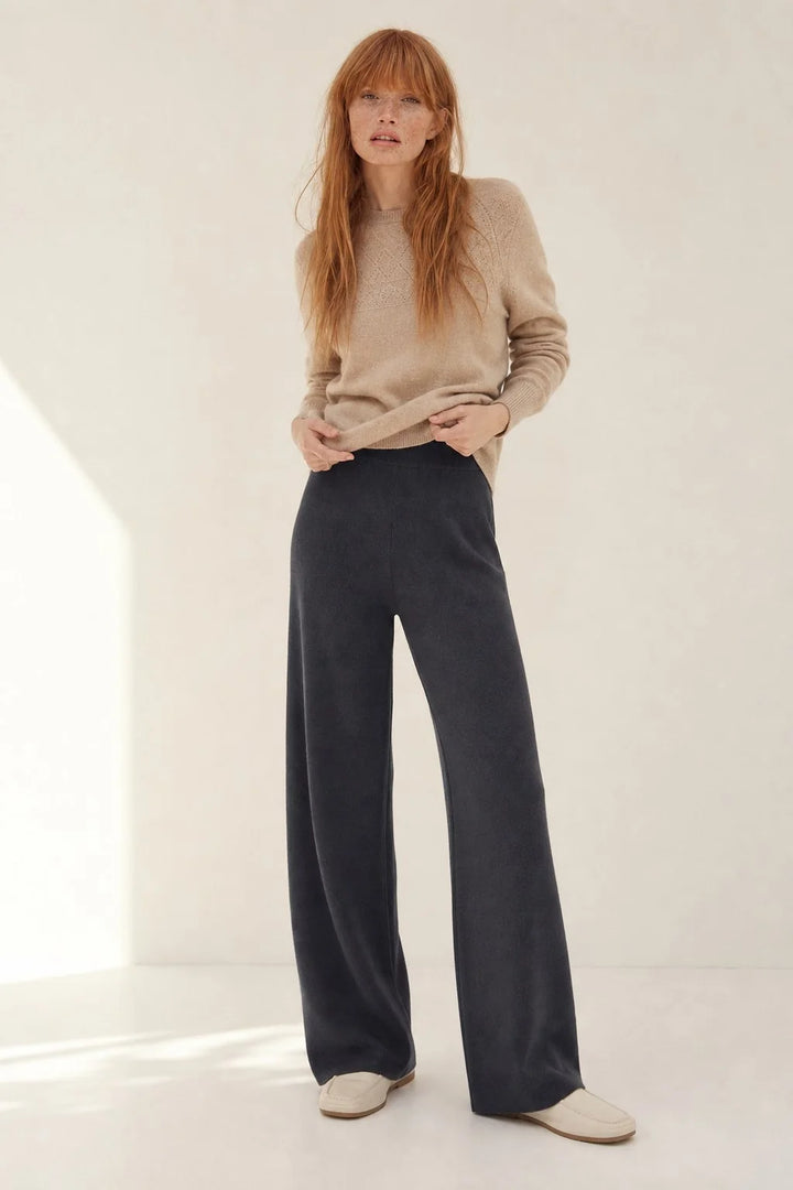 Woman wearing cream wide-leg Merino Pants in relaxed seated pose showing comfortable fit